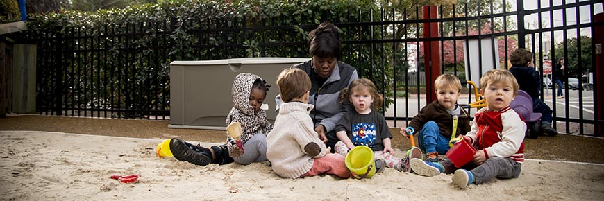 A group of students play outside in the playground at the Child Development Center.